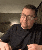 a man wearing glasses is eating a piece of food
