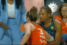 a basketball player with the number 3 on her jersey talks to another player