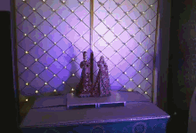 a couple of statues sitting on a table in front of a wall with purple lights