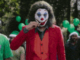 a man dressed as a clown eating a lollipop