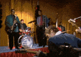 a man is playing a guitar in front of a drum that says " the eric annes "