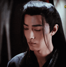 a close up of a man with long black hair