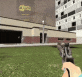 a person holding a gun in front of a building that says gravity gun on it