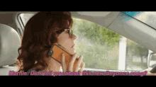 a woman is driving a car and talking on a cell phone