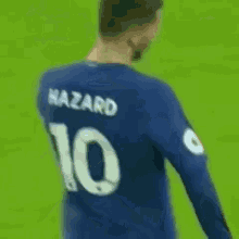 a soccer player wearing a blue shirt with the number 10 on it is walking on a field .