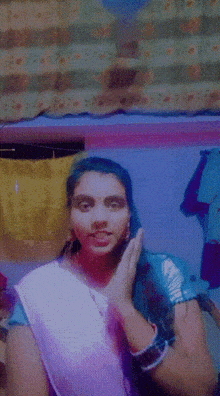 a woman with blue hair is making a funny face with her hand on her face