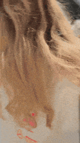 a close up of a woman 's hair with a pink nail polish stain