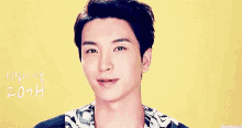 a close up of a young man 's face with a yellow background and korean writing on it .