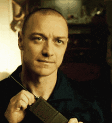 a man in a black shirt is holding a walkie talkie in his hand