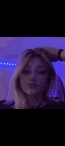 a close up of a woman 's face with a blurry background and blue lights behind her .