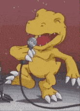 a yellow dinosaur is singing into a microphone while standing on a stage .