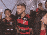 a man in a red and black shirt with the word devx art on it