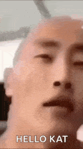 a close up of a man 's face with his eyes closed and the words `` hello kat '' written on the bottom .