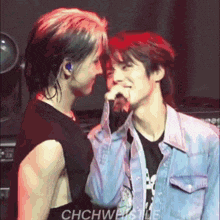 two men are standing next to each other on a stage .