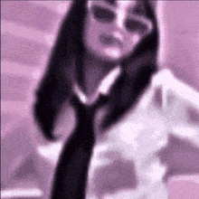 a blurred image of a woman wearing sunglasses and a black tie