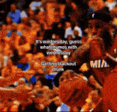 a basketball player in a mia jersey holds a basketball in front of a crowd of people
