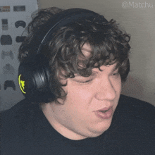 a man with curly hair wearing a pair of headphones with the name matchu written on the bottom