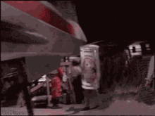 a man is holding a can of soda under a car