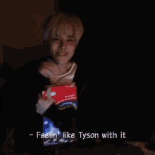 a person sitting in a dark room with the words feelin ' like tyson with it knock it out twice
