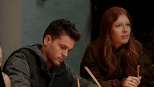 a man and a woman are sitting at a table with a straw in their mouths