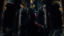 a man in a superhero costume is standing in a dark room