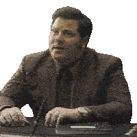 a man in a suit and tie sits at a desk with a pen in his hand