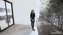 a woman is standing in an empty room with the words made in animotica on the bottom