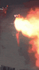 a jet is flying through the air with flames coming out of it 's tail