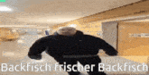 a man in a black jacket is running in a hallway with the words backfisch frischer backfisch written below him