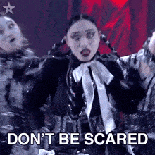 a woman is dancing on a stage with the words do n't be scared behind her