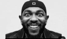 a black and white photo of a man with a beard wearing a hat making a funny face .