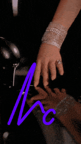 a woman wearing a bracelet and a ring has a purple arrow pointing to the letter c