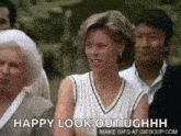 a woman is standing in front of a crowd of people and making a funny face .