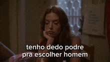 a woman sitting at a table with the words tenho dedo pode pra escolher homem
