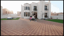 a man jumping in front of a white house