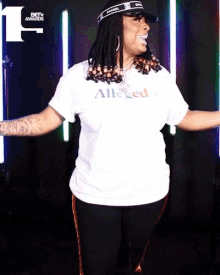 a woman wearing a white t-shirt that says all i need