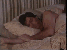a man and a woman are laying on a bed and the woman is holding the man 's arm
