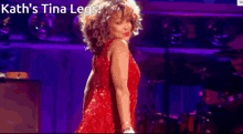 a woman in a red dress is dancing on a stage with the words kath 's tina legs