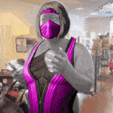 a woman wearing a pink mask and a purple top