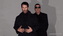 two men with black paint on their faces and a gifrun.com watermark