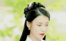 a woman is holding her hair in a braid while wearing a white kimono .