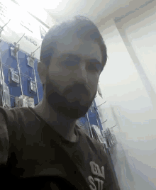 a man with a beard is wearing a t-shirt that says ' gn ' on it
