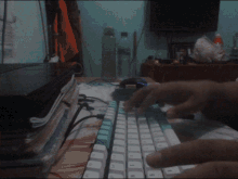 a person is typing on a keyboard with a bottle of water behind them