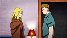 a man and a woman standing next to each other with a lamp in the background
