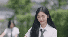 a girl with long black hair and a white shirt and tie