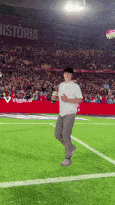 a man stands on a soccer field with a sign that says historia