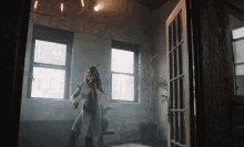 a woman is playing a violin in a room