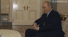 a man in a suit and tie is sitting in front of a door with the hashtag doggeopolitics on the bottom