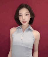 a woman in a blue halter top is standing in front of a red background .