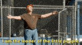 a man standing in front of a chain link fence with his arms outstretched and the words i am the leader of the little people